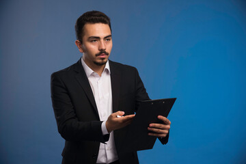 Businessman in black suit checking the tasks