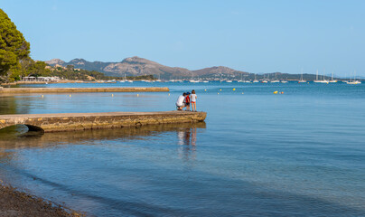Father with children on the pier in Port de Pollença