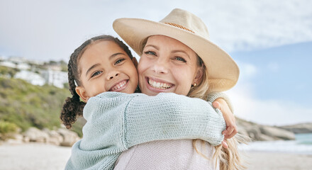 Portrait of a little girl bonding and hugging her mother at the beach. Carefree mom having fun with...