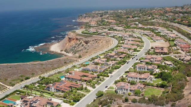 Aerial view of homes in Palos Verdes next to Pacific Ocean cliffs and waves