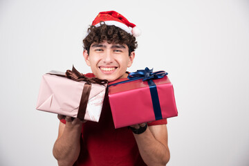 Young man holding gift boxes and smiling
