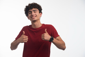 Young boy with curly hairstyle doing thumb up