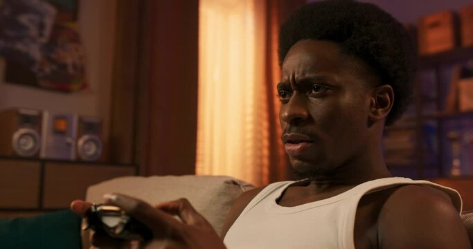 Close-up of a console pad used by a man while playing games on a TV set, a round of football game, relaxing after work, focused guy young student enjoying the vitrual world.