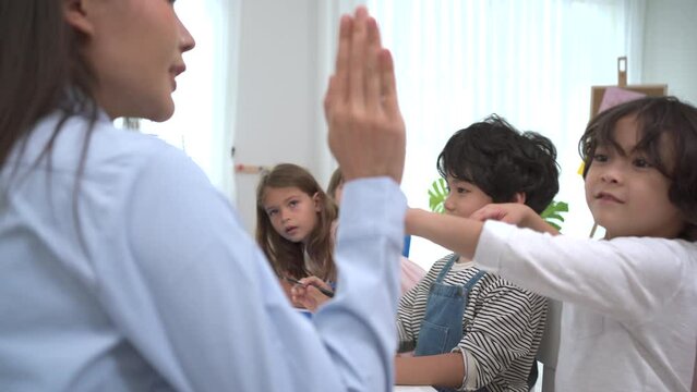 Caucasian white female teacher teaching children in classroom.
