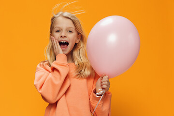 cute, happy girl stands with a pink balloon in her hand and screams loudly