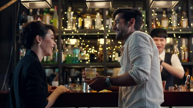 4K Caucasian man and woman flirting each other while hangout nightlife party at restaurant bar. Attractive female have romantic dating with boyfriend celebrating holiday event together at nightclub