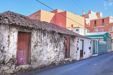 Exterior of a decaying brick building. Architecture of an abandoned property or an old vintage demolished house with a weathered roof on a narrow street in Santa Cruz de La Palma