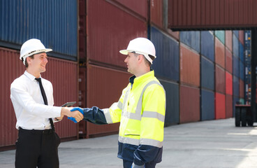 Caucasian manager shaking hands with colleague celebrating the success of container shipping on time.