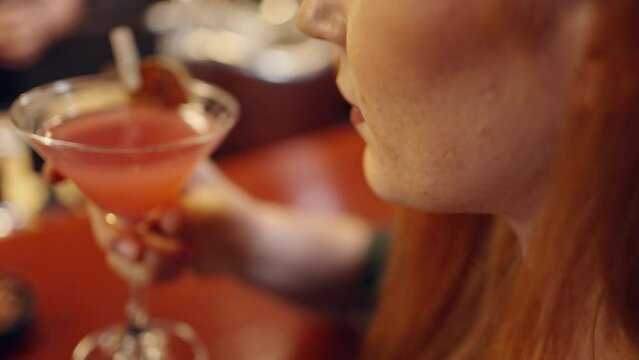 Close up of Attractive Caucasian woman relax and enjoy hangout nightlife and drinking fancy cocktail at luxury restaurant bar. Beautiful female celebrating holiday event party at nightclub in the city