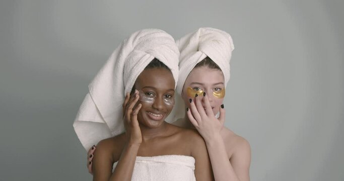 Multiracial girl with eye patches posing over grey background