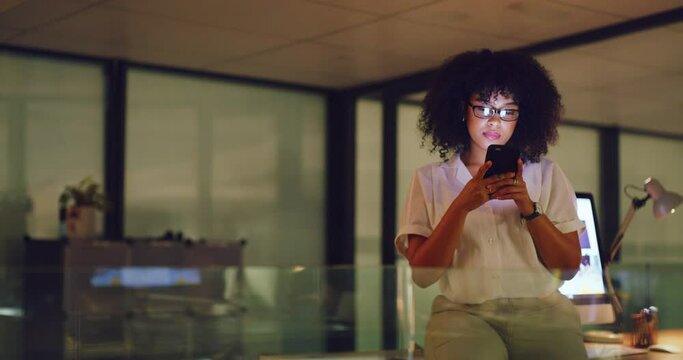 Young business woman typing a text online on a phone while working late in an office. One corporate female professional browsing social media on the internet while doing overtime at work alone