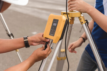 A surveyor setting up a HDL wireless data transceiver. Surveying equipment used in the field. - obrazy, fototapety, plakaty