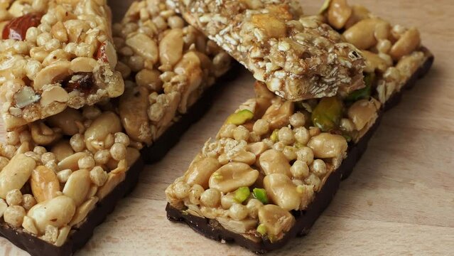 Cereal superfood energy bars with almond nuts, dry fruits, raisins chocolate on the wood table