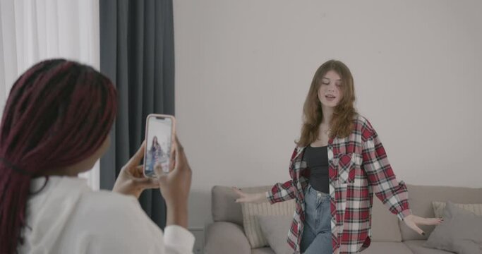Two teenage girls filming video vlog at home