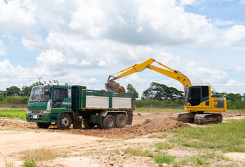 Excavator adjust surface soil and loading to truck.