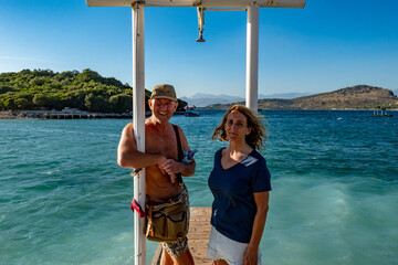 Ksamil, Albania, A tourist couple on the beach under azure skies.