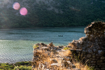 Ksamil, Albania, A small fishing boat in lake Butrint surrounded by ruins in the  National Park of Butrint, an ancient city from Greek and Roman times.