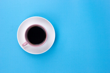 An isolated black coffee on light pink cub on light blue background