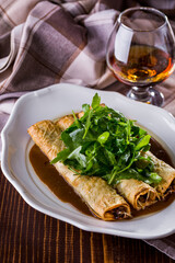 Pancakes with veal and cheese and a glass of cognac