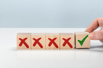 Man Hand selects checkbox with green checkmark from row of multiple boxes with red crosses. Right or Wrong. Concept of positive or negative decision making or choice of approval or rejection