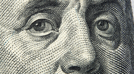 Close up view Portrait of Benjamin Franklin on one hundred dollar bill. Franklin eyes macro. 100 dollar bill with Benjamin Franklin eyes macro shot.