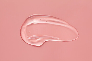 Cosmetic serum gel beauty swatch smear smudge on pink color background. Skincare beauty product with bubbles texture