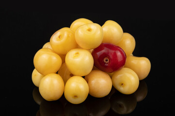 A bunch of yellow cherries with one red berry in the center