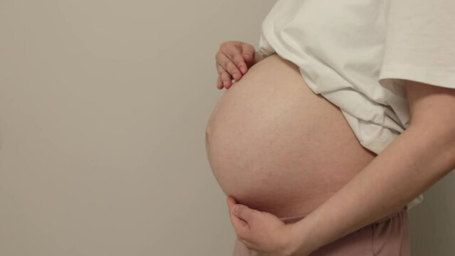 Cropped view of pregnant girl touching big belly getting ready for fatherhood isolated on gray background