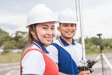 Two surveyors using RTK geodetic surveying equipment. A male and female engineer working in the...