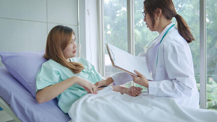 Smiling Asian woman pediatrician give advice to patients , Young asia female doctor consult female patient and checkup in hospital , healtcare and assistance concept © Mizkit