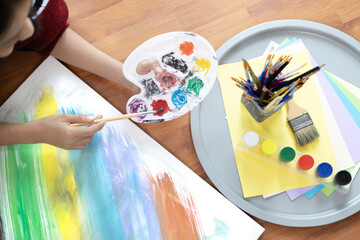 Fototapeta premium Female artist painting on canvas, Artist studio interior, Draw with watercolor, Drawing supplies , Painting and creativity, Use a brush to draw a pattern by stripes, Artwork, Using Paint Brush.