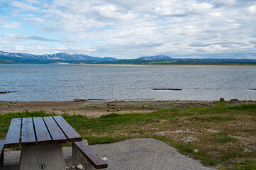 Wooden table overlooking lake surrounded by mountains