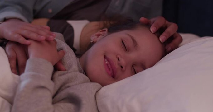 Cheerful mother and daughter in bed at night