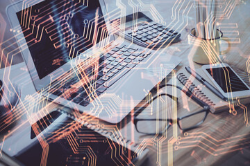 Computer on desktop in office with technology theme hologram. Double exposure. Tech concept.