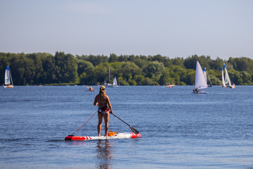 Naklejka premium woman is engaged in rowing on the board