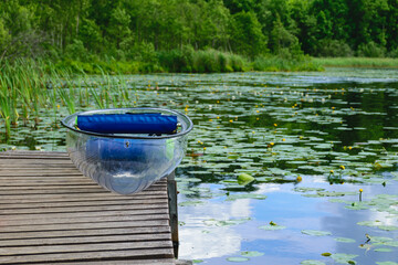landscape with a transparent plastic boat, exploring a wild lake