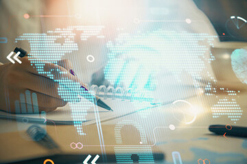 Multi exposure of hands making notes with world map hologram and data theme icons. Concept of global data.