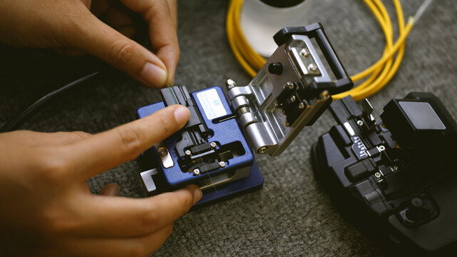 Fiberoptic Fusion Splicing Technician , Internet cable connection, fiber optic fusion splicing machine. Concept of fiber optic connection by skilled technicians.