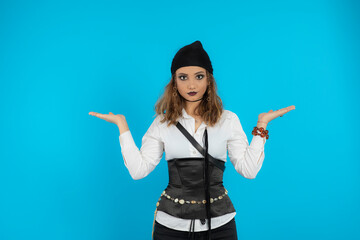 Portrait of young pirate girl stand on blue background