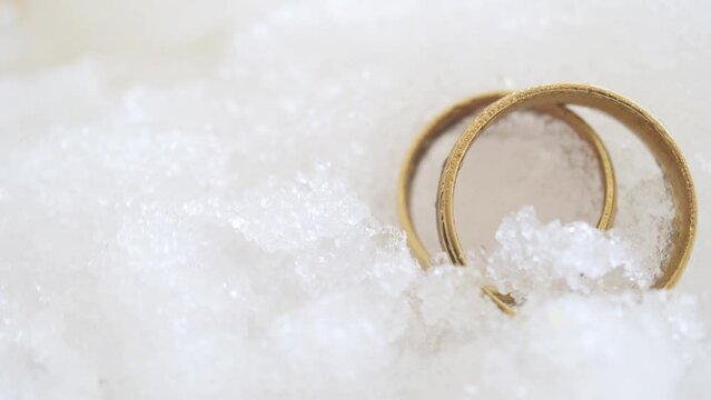 Gold wedding rings in snow close up