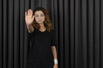 Portraits of depressed young girl putting her hand to the camera and gesture to stop