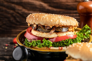 Homemade burger with grilled meat, vegetables, sauce on rustic wooden background. fast food and junk food concept