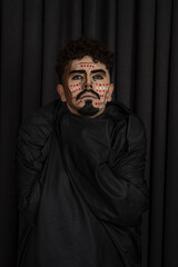 Fototapeta premium Vertical photo of young man in black kerchief on black background