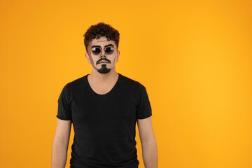 Young creative man stands on orange background