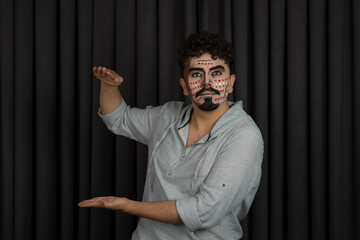 Young man was creative makeup gesture length with hands and looking at the camera