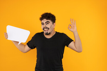 Smiling young man with pop art makeup holding idea bored and gesture OK