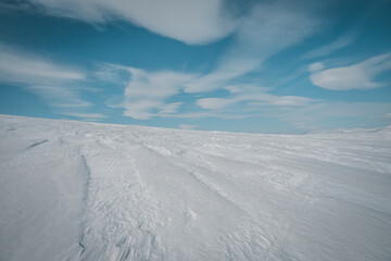 Conceptual background of snow and blue sky with beutiful clouds. Copy space. Photo taken in Helags Mountain area, swedish Lapland.