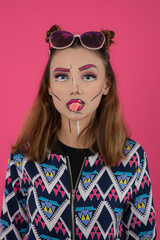 Close up portrait of young girl wearing creative makeup and holding gum with mouth