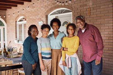 Portrait of happy black multi-generation family on patio looking at camera.