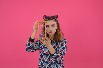 Bianca beautiful girl wearing fantasy makeup and holding sand clock.